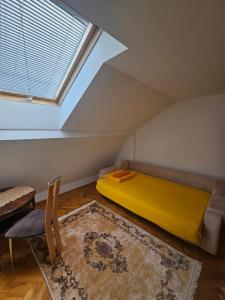 a bedroom with a yellow bed and a window at Old Bazaar Altunalem Stay in Novi Pazar