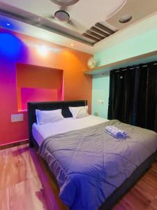a large bed in a room with colorful walls at Aru Homestay Hampi in New Hampi