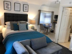 沃尔索尔Anson Studios Walsall M6, J10的卧室里有一张大床，上面铺着蓝色毯子