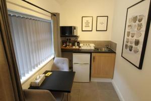 a small kitchen with a table and a sink at Anson Studios Walsall M6, J10 in Walsall