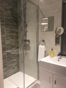 a bathroom with a glass shower and a sink at Anson Studios Walsall M6, J10 in Walsall