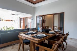 Un comedor con mesa y sillas de madera. en Villa Sakura III Seminyak, en Seminyak