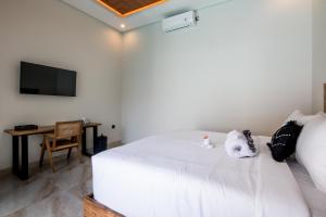 Un dormitorio con una cama con dos animales de peluche encima. en Villa Sakura III Seminyak, en Seminyak