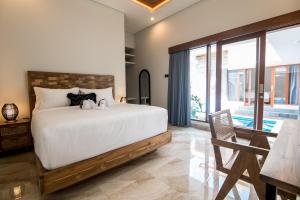 Un dormitorio con una cama, una mesa y una silla. en Villa Sakura III Seminyak, en Seminyak 11 fotos más