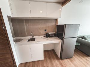une petite cuisine avec un évier et un réfrigérateur dans l'établissement FAMILY HOMES Wyndham - Spacious 2BDRM Just Steps from Rawai Beach, à Ban Saiyuan (1)
