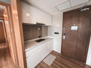 une cuisine avec des armoires blanches et une porte en bois dans l'établissement FAMILY HOMES Wyndham - Spacious 2BDRM Just Steps from Rawai Beach, à Ban Saiyuan (1)