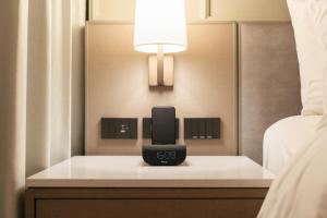 un reloj en una mesa junto a una cama en Courtyard by Marriott Bangkok Sukhumvit 20, en Bangkok
