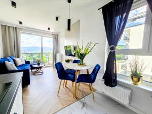 a living room with a table and blue chairs at Apartament M&A Panorama in Jelenia Góra