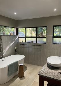 a bathroom with a tub and a sink and a bath tub at Cycasia Lodge in Umzumbe