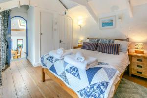 ein Schlafzimmer mit einem Bett mit Handtüchern darauf in der Unterkunft Smugglers Cottage in Porthleven