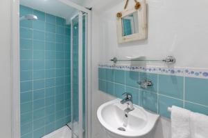 ein Badezimmer mit Waschbecken und Dusche in der Unterkunft Smugglers Cottage in Porthleven + 13 Fotos