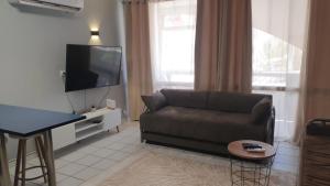 a living room with a couch and a flat screen tv at דירות לב אילת - lev eilat - מרחק 500 מטר מהים קניון וטיילת - מקבלים נוער in Eilat
