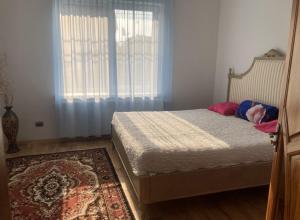 a bedroom with a bed and a window and a rug at Golden House in Khust