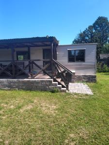 a home with a porch and stairs to it at Leśna Aura in Ponizie