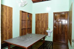 a room with a table and a toilet and a door at Samuals Villa Wayanad in Mānantoddy