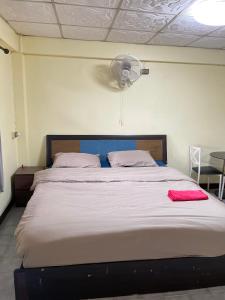 a bedroom with a large bed with a fan at Haiya Guesthouse room 9 in Chiang Mai