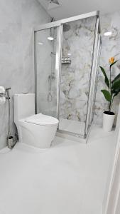 a white bathroom with a shower and a toilet at Patong Tower 2 Bedroom Sea View in Patong Beach