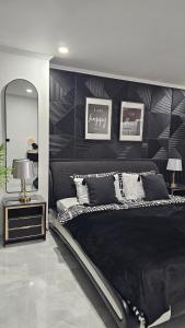 a bedroom with a black bed and a mirror at Patong Tower 2 Bedroom Sea View in Patong Beach