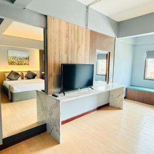 a large living room with a television and a bed at Best LD Hotel โรงแรมเบส แอลดี in Hua Hin