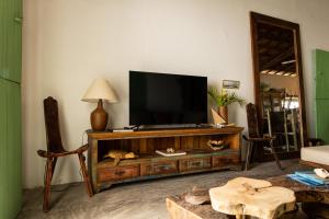 a living room with a flat screen tv on a entertainment center at Casa Mangará in Cruz