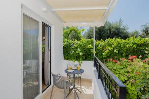 a patio with a table and chairs on a balcony at Pension Zoi Luxury Room in Kolymbia