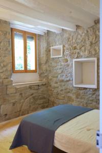 CorbínsにあるLes Cases del Molinerのベッドと石の壁のある寝室