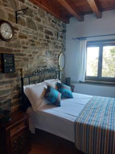a bedroom with a bed and a brick wall at Παραδοσιακός ξενώνας Ναϊάς in Zagora