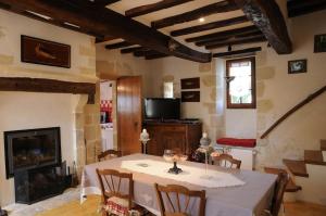 Saint-Germain-des-GroisにあるAu bord de l'Huisneのテーブルと暖炉のあるダイニングルーム