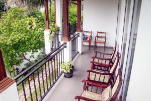 a balcony with rocking chairs and a table at Lotus Villa in Katunayake
