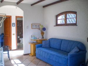 a blue couch in a living room with a window at Casa Marica in Porto Valtravaglia
