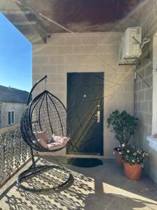 einen Stuhl auf einem Balkon mit Tür in der Unterkunft Chelo Guest House in Kutaissi