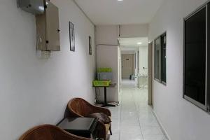a hallway with chairs and a television on a wall at Persona Boutique Hotel in Malacca