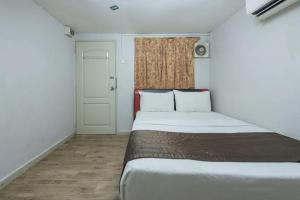 a small bedroom with a bed and a window at Persona Boutique Hotel in Malacca