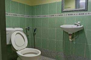 a green bathroom with a toilet and a sink at Persona Boutique Hotel in Malacca +30 photos