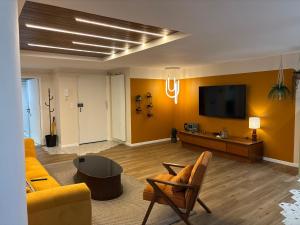 a living room with a couch and a tv at Cozy Loft tout équipé au cœur de Saint-Lô in Saint Lo