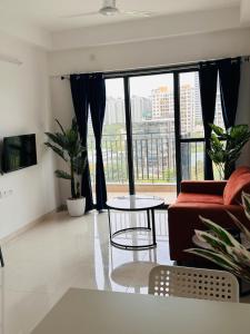 a living room with a couch and a table and a large window at Joy Pvt 1Bhk in Amanora Most Awarded Township in Pune +17 photos