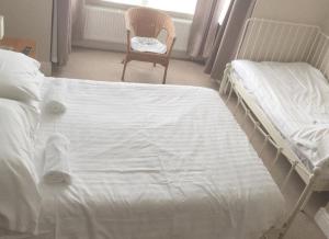 a bedroom with two twin beds and a chair at Ipswich Inn in Ipswich