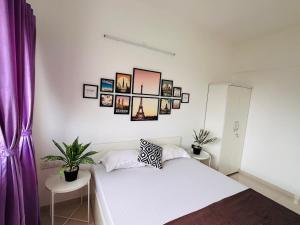a bedroom with a white bed with pictures on the wall at Joy Pvt 1Bhk in Amanora Most Awarded Township in Pune