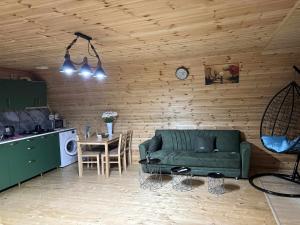 a living room with a green couch and a table at house milena in Kobuleti
