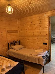 a bedroom with a bed in a wooden cabin at house milena in K'obulet'i