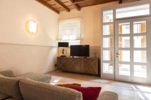 a living room with a couch and a tv and a door at Dante Alighieri intero appartamento luxury in Verona