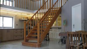 a wooden staircase in a kitchen with a table and chairs at Villa Hermes, Spacious Getaway in Mytilene in Mytilene