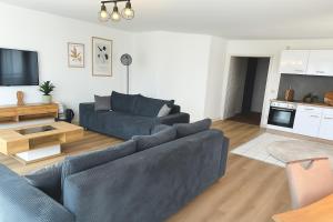 ライプツィヒにあるCity Lodge Leipzigの青いソファとテレビのあるリビングルーム +6枚の写真