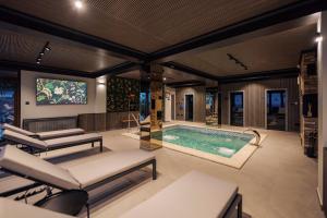 a room with a swimming pool and a tv at Ikabane in Agapia