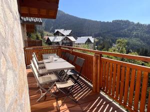 een houten terras met een tafel en stoelen erop bij NEW Chalet Le Sabot 12p - Sauna - 90m telecabine in Oz