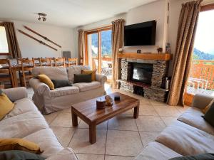 een woonkamer met banken en een open haard met een televisie bij NEW Chalet Le Sabot 12p - Sauna - 90m telecabine in Oz