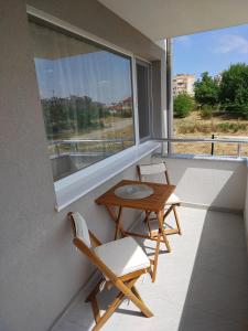 Un balcón con dos sillas y una mesa y una ventana. en Luxury new apartment, en Stara Zagora