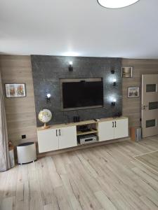 Una sala de estar con un televisor de pantalla plana en una pared. en Luxury new apartment, en Stara Zagora