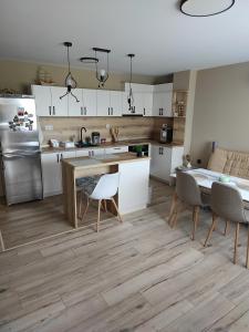 Una cocina con gabinetes blancos y una mesa y sillas. en Luxury new apartment, en Stara Zagora