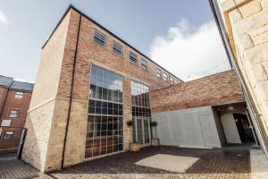 a brick building with a garage in front of it at The Wildings Northumberland in Morpeth